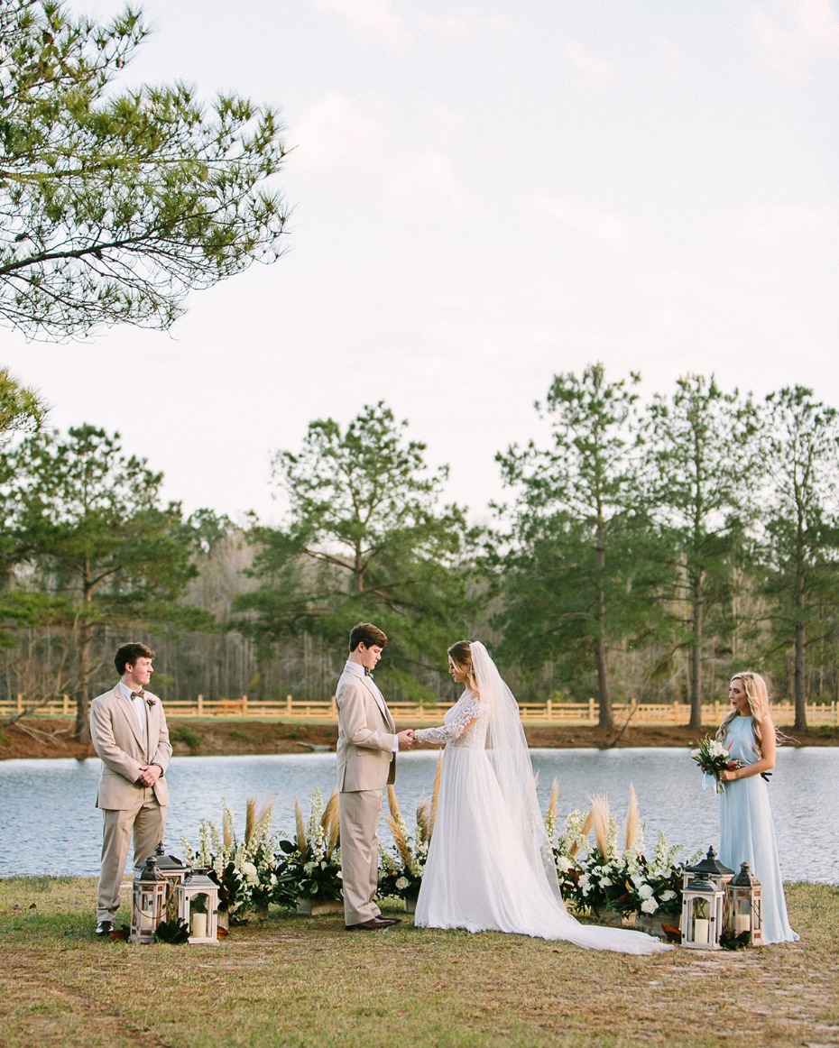 Bride and groom at outdoor wedding ceremony by lake