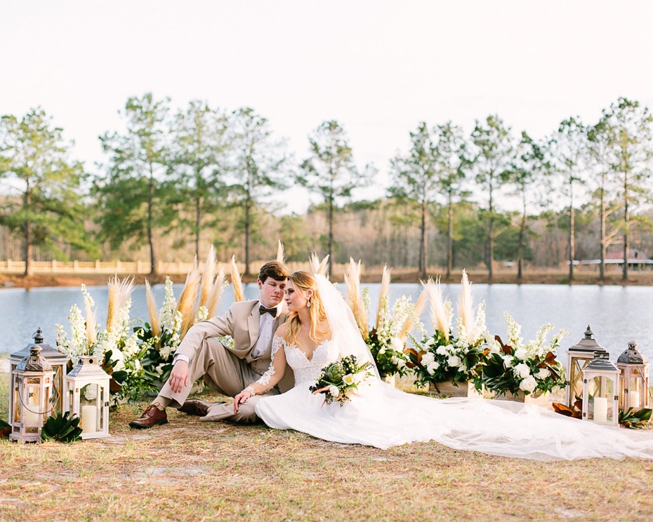 Bride and groom pose at rustic outdoor wedding lakeside
