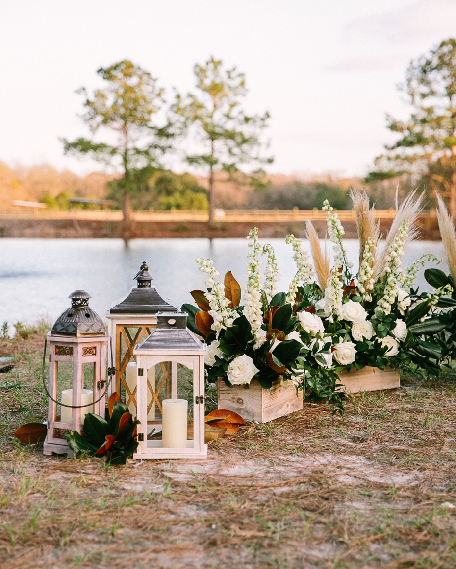 Lanterns and floral arrangement by lake for wedding decor