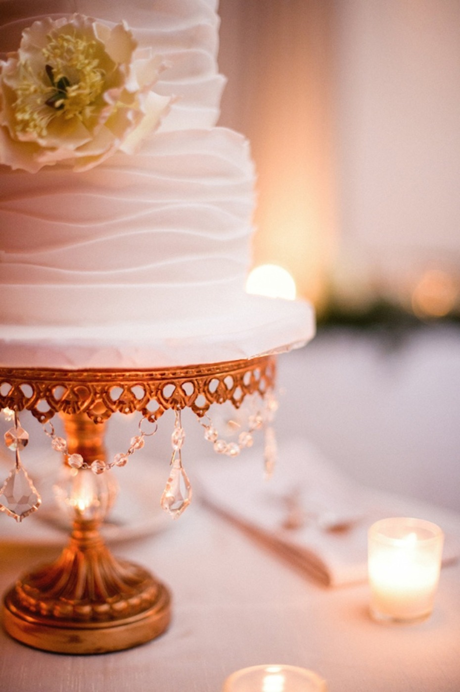 Elegant white wedding cake with floral accents and candles