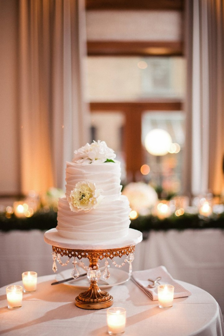 Elegant two tier wedding cake with flower and candle decor