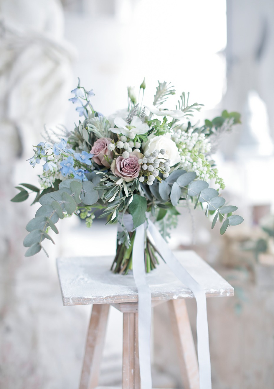 Elegant wedding bouquet with roses and eucalyptus on a small stool