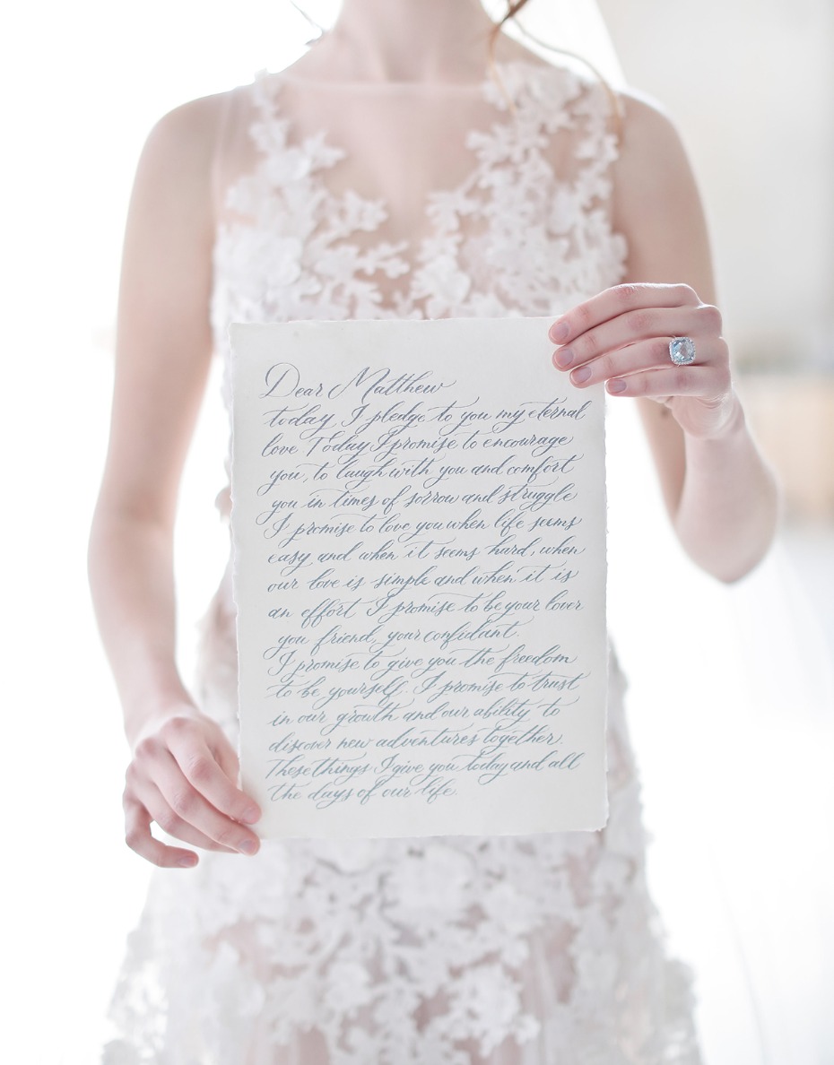 Bride holding a handwritten wedding vow to her groom on paper