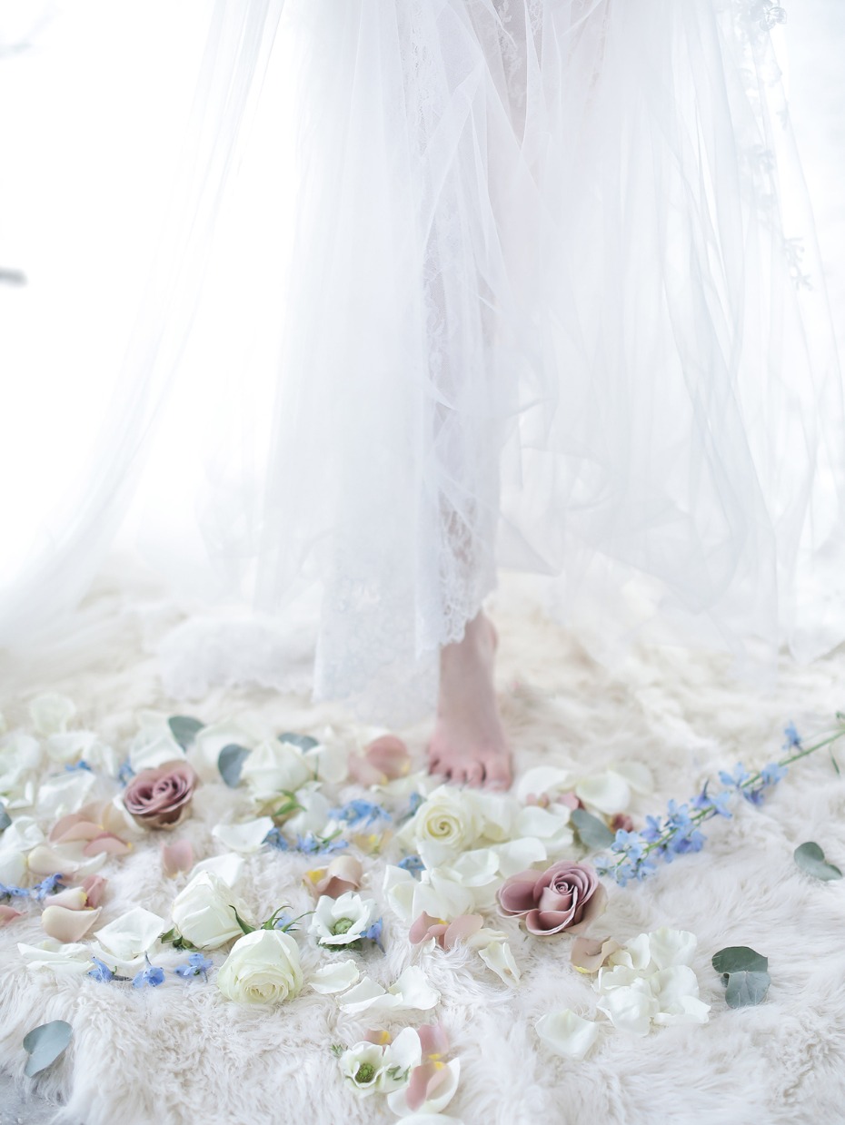 Bare feet walking on white floral carpet and soft tulle