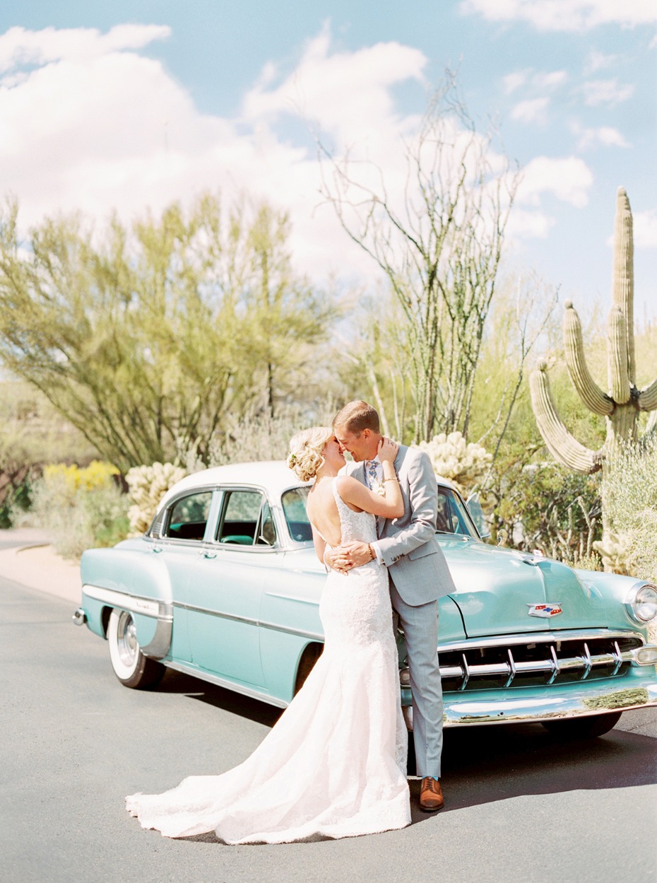bride and groom and their wedding getaway car