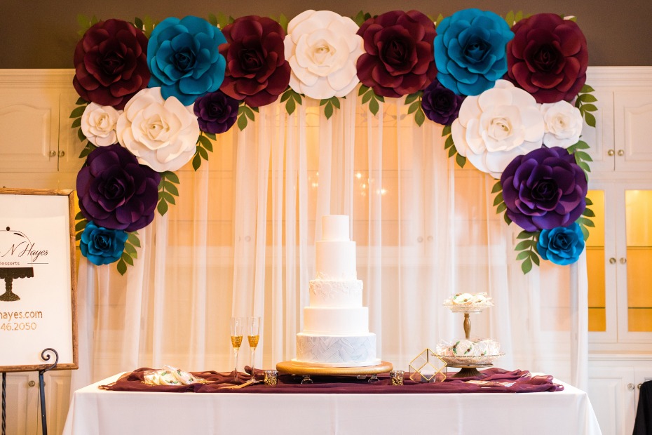 wedding cake table with paper flower backdrop