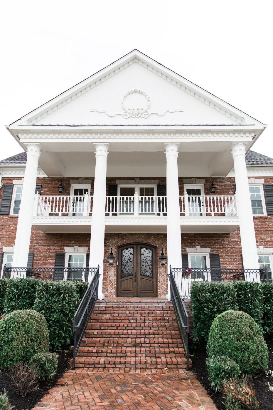 Elegant brick home with grand entrance and columns