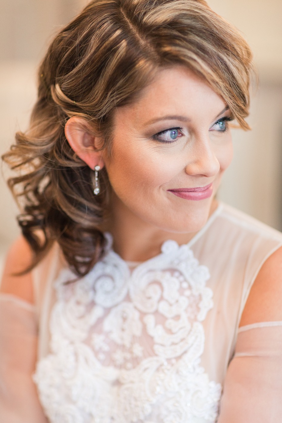 Bride in elegant lace wedding dress, soft makeup