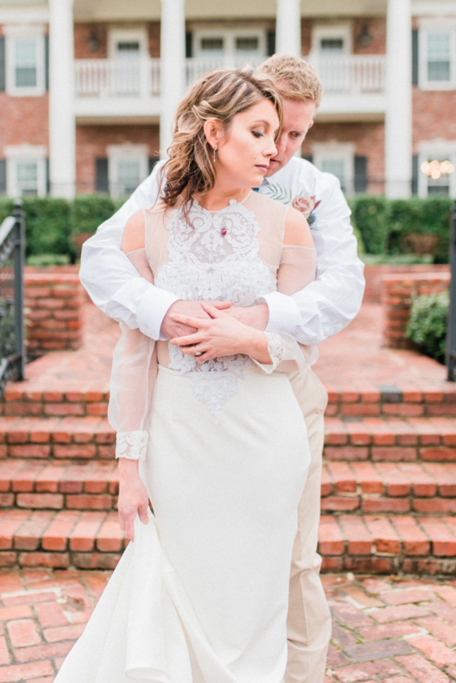 Bride and groom embrace on brick steps