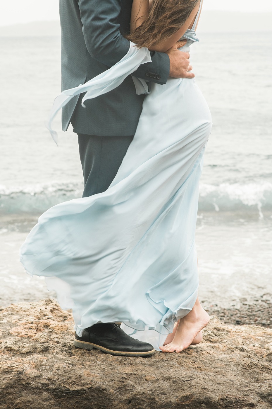 a bride and groom at the beach