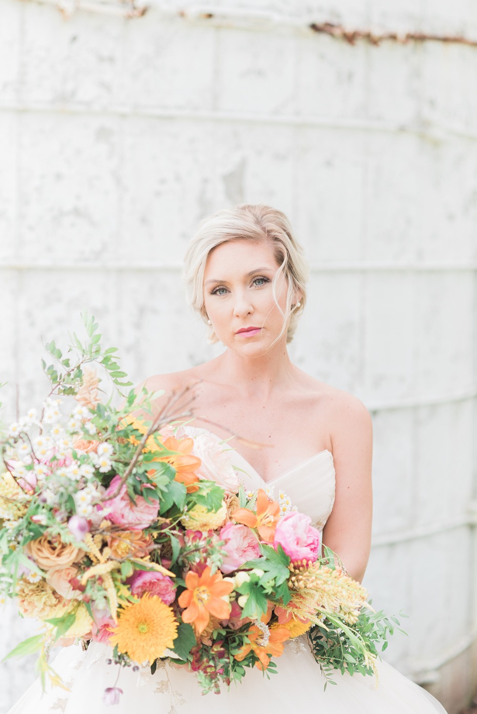 bride with bright orange and yellow bouquet