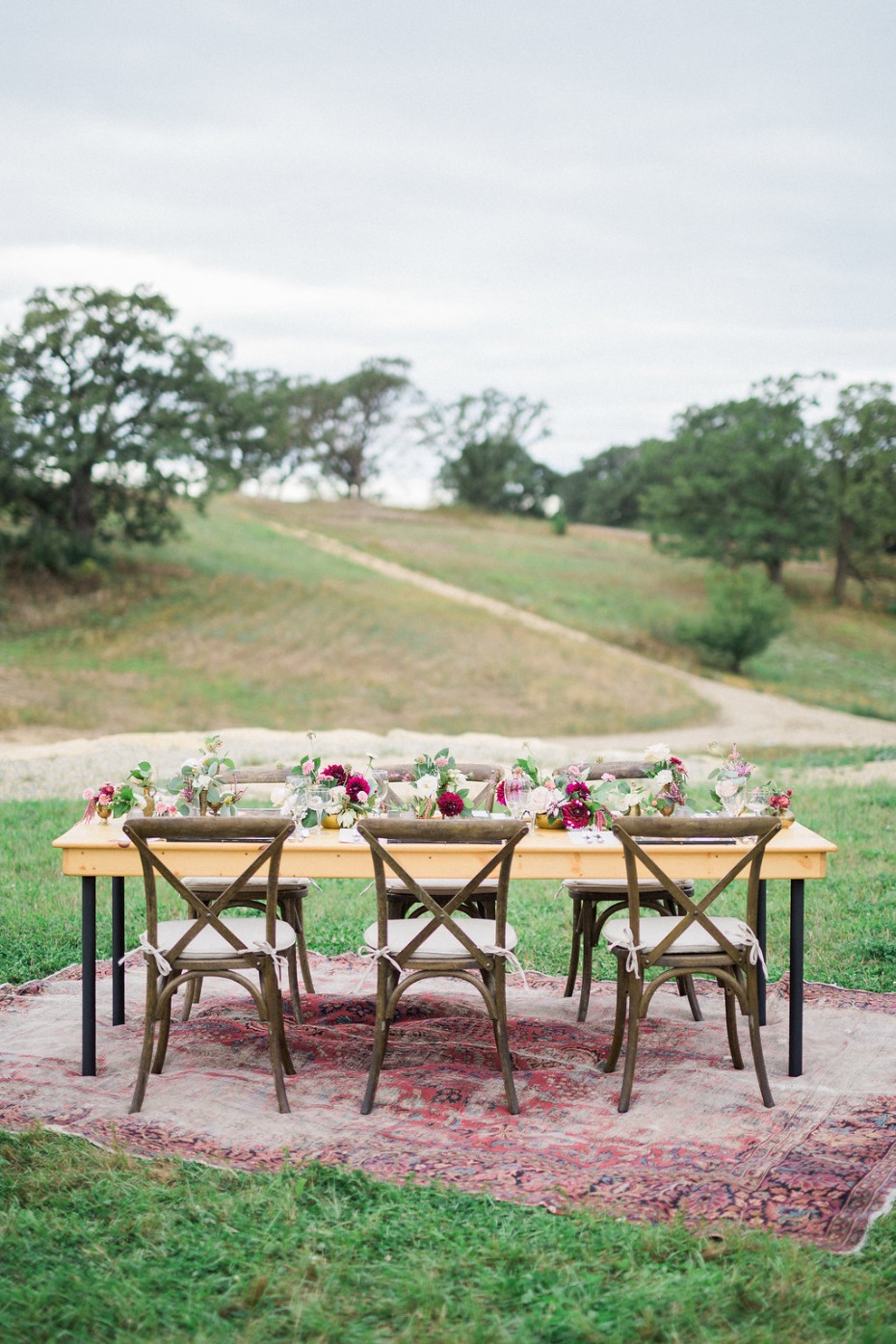 Rustic wedding table with chairs in a countryside field