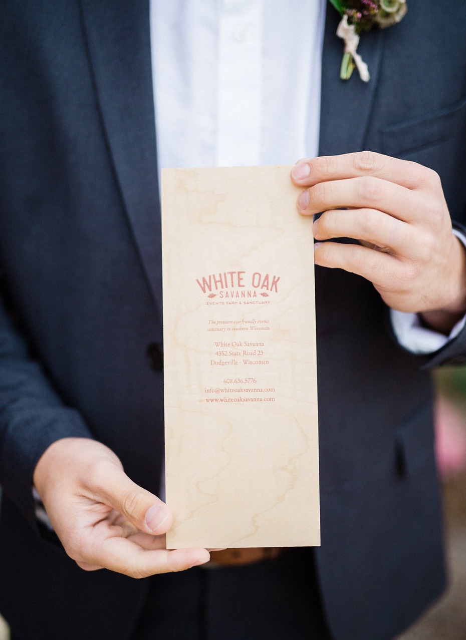 Groom holds a White Oak Savanna venue information card