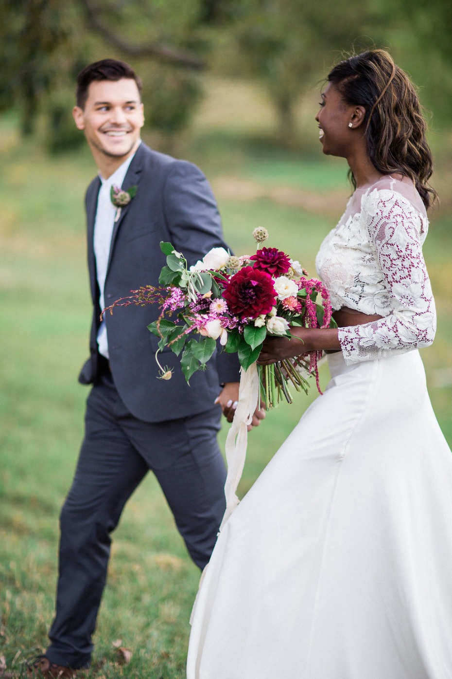 Happy bride and groom walk holding hands on wedding day