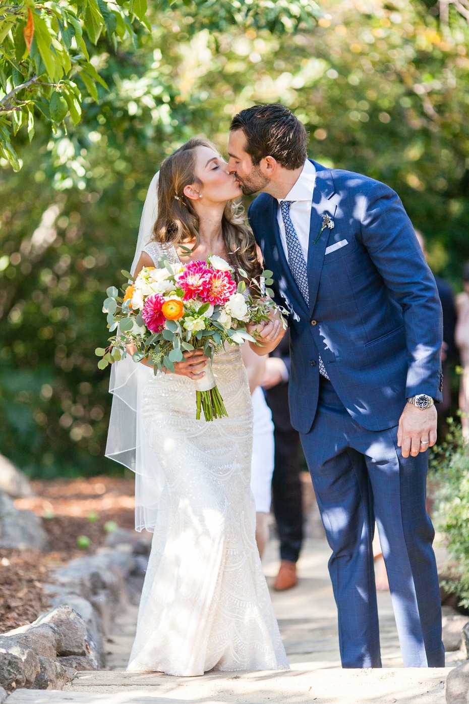 Newlyweds share a kiss at their outdoor garden wedding