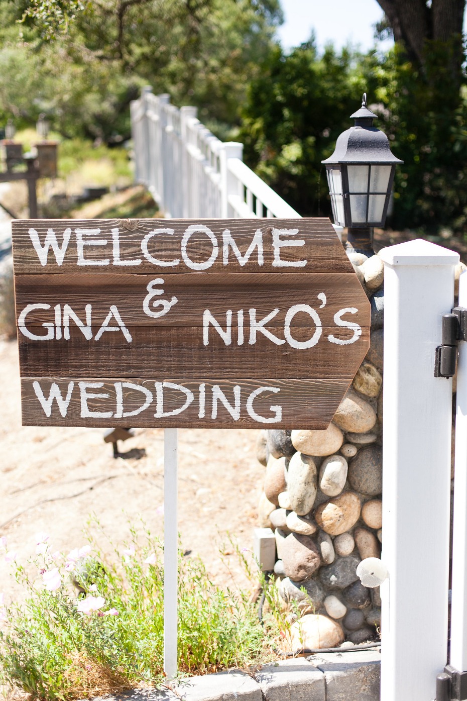 Gina and Nikos wedding welcome sign on wooden plank