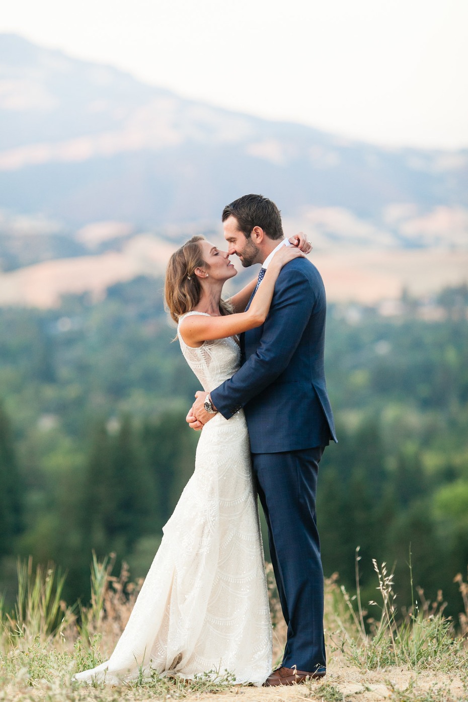 Bride and groom kissing with mountains in background