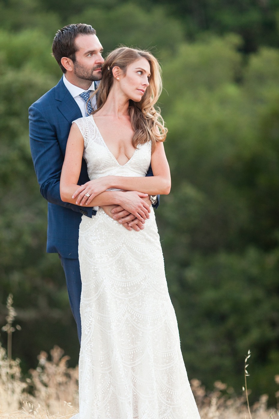Bride and groom embrace in stunning wedding attire