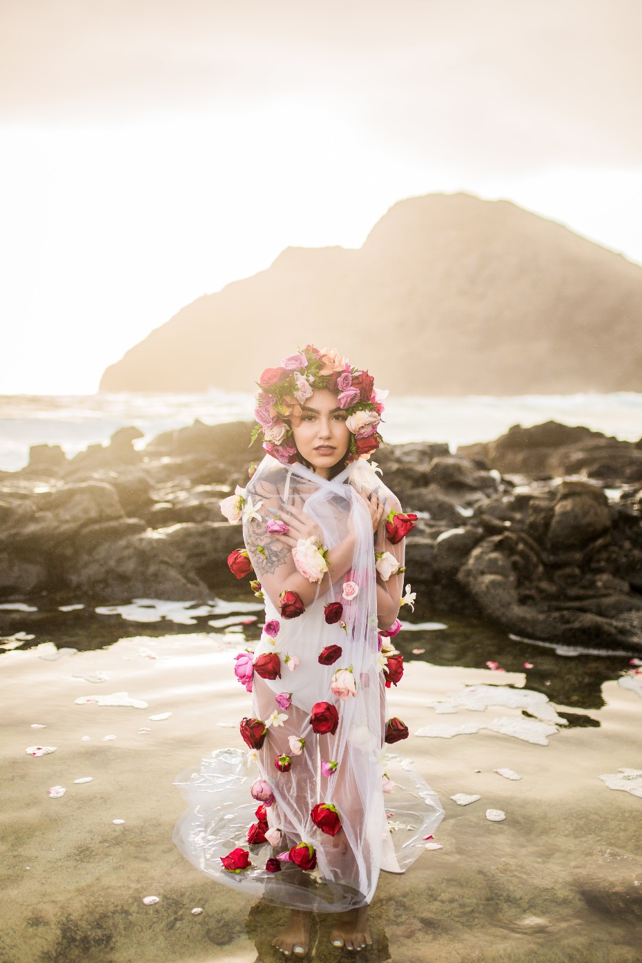 Woman in floral crown and dress on beach landscape