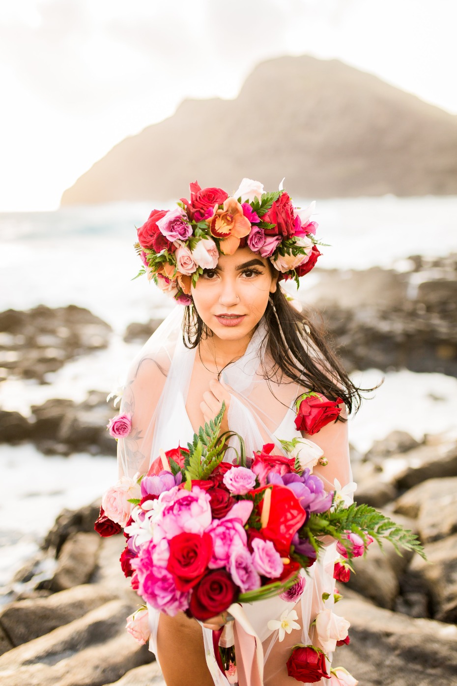 Woman with flower crown and bouquet on a rocky beach