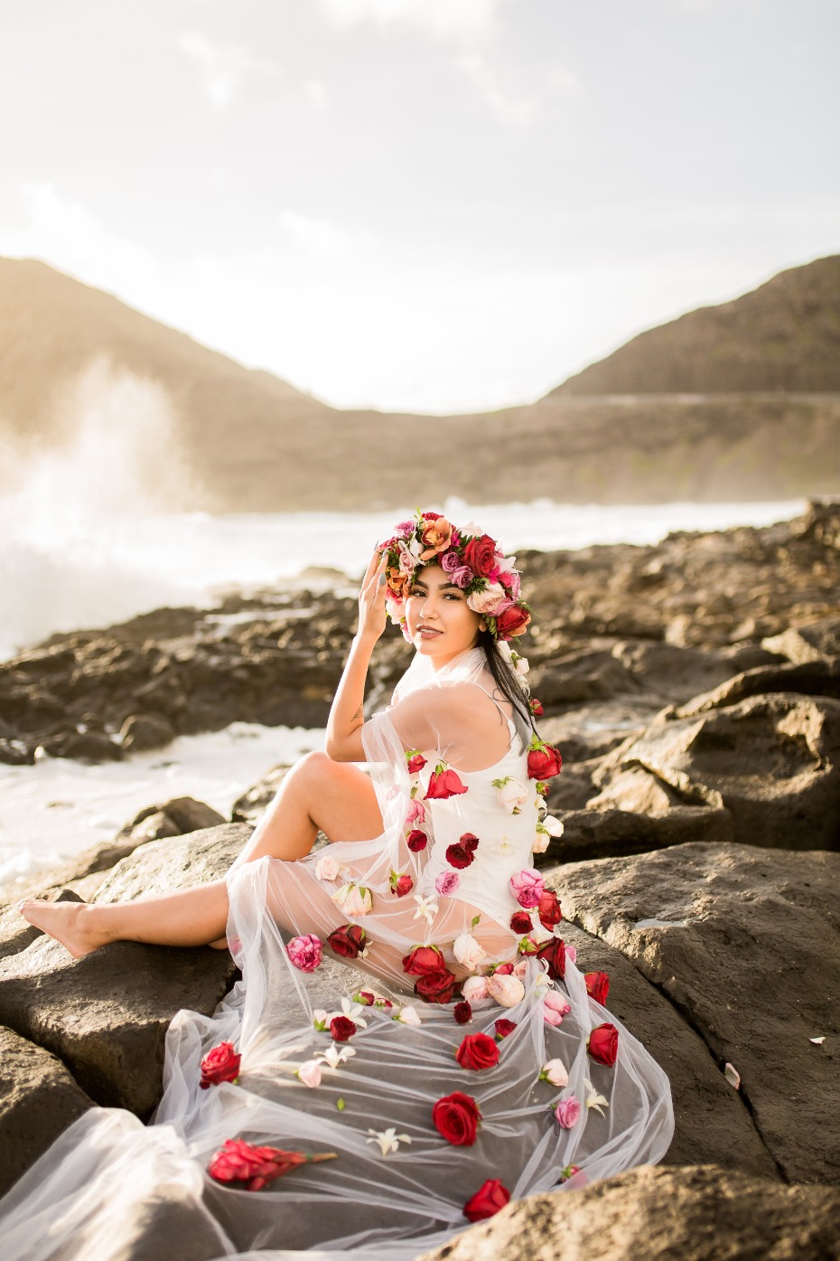 Woman in floral dress on rocky beach landscape