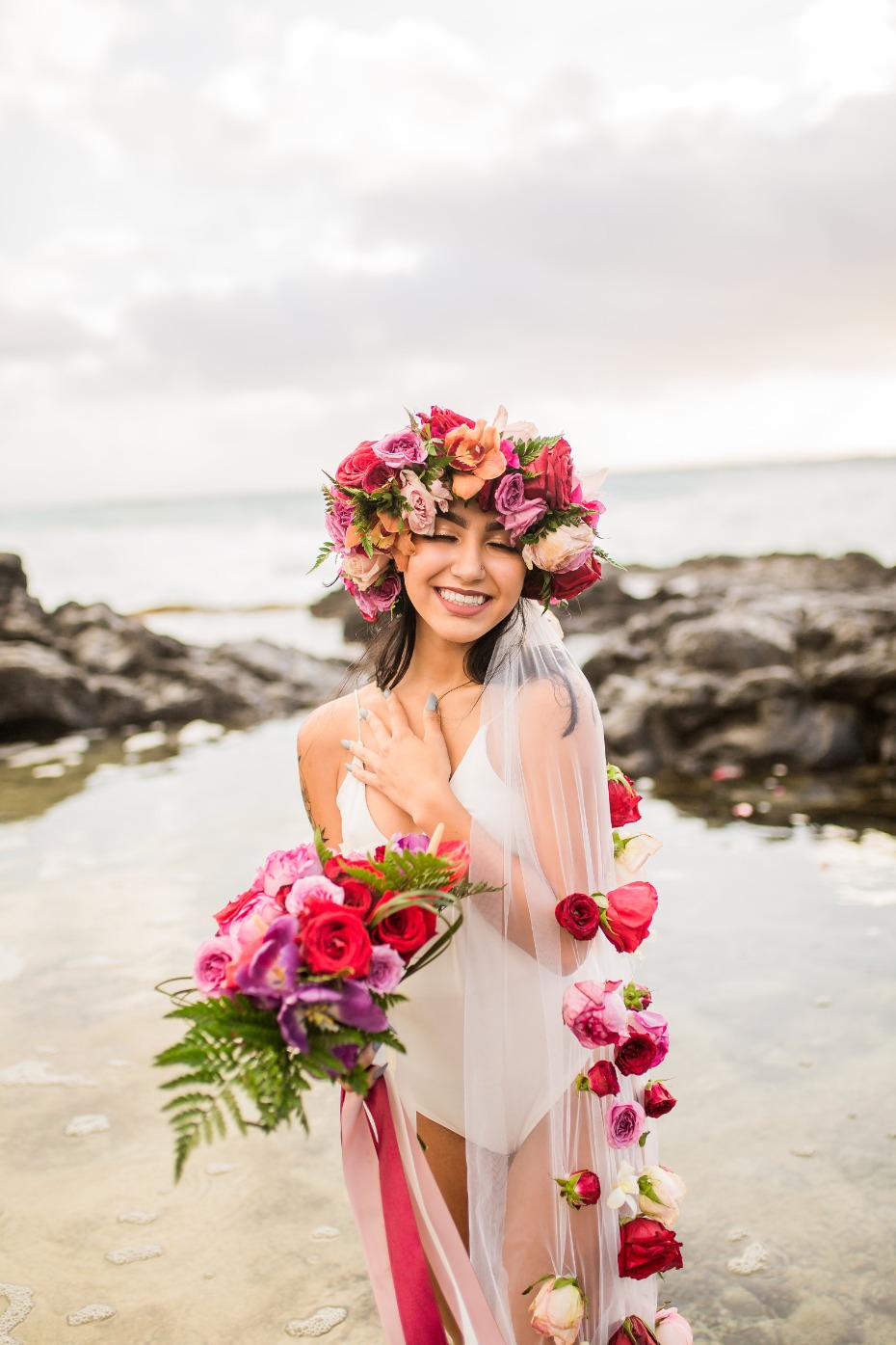 Woman with floral crown and bouquet on beach
