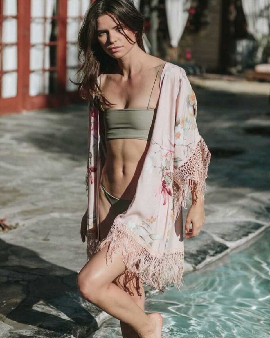 Woman in pink floral kimono by a pool