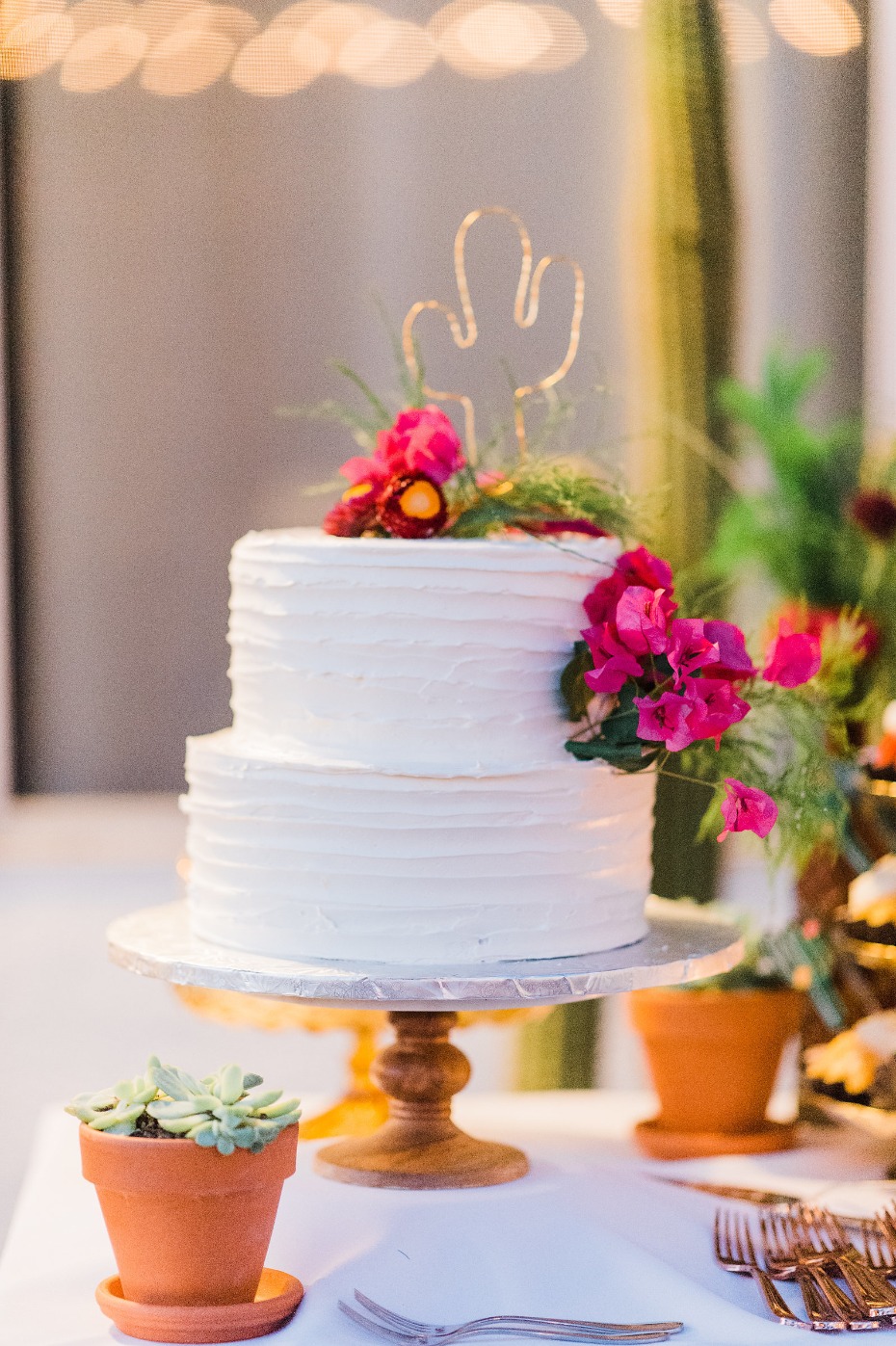 White wedding cake with a wire cactus topper