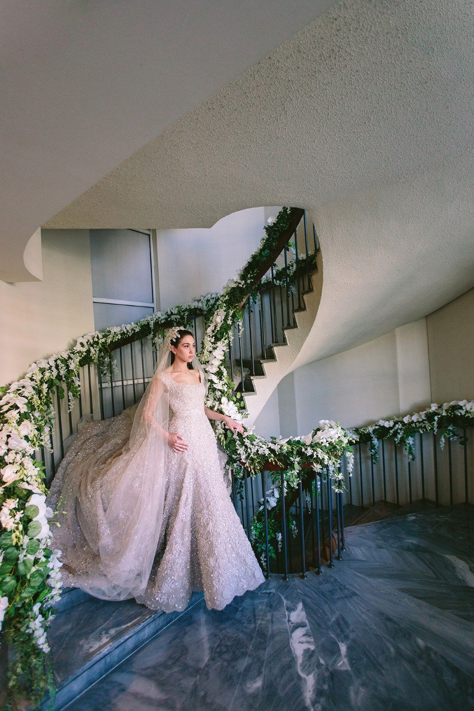 a bride descending a flower draped staircase