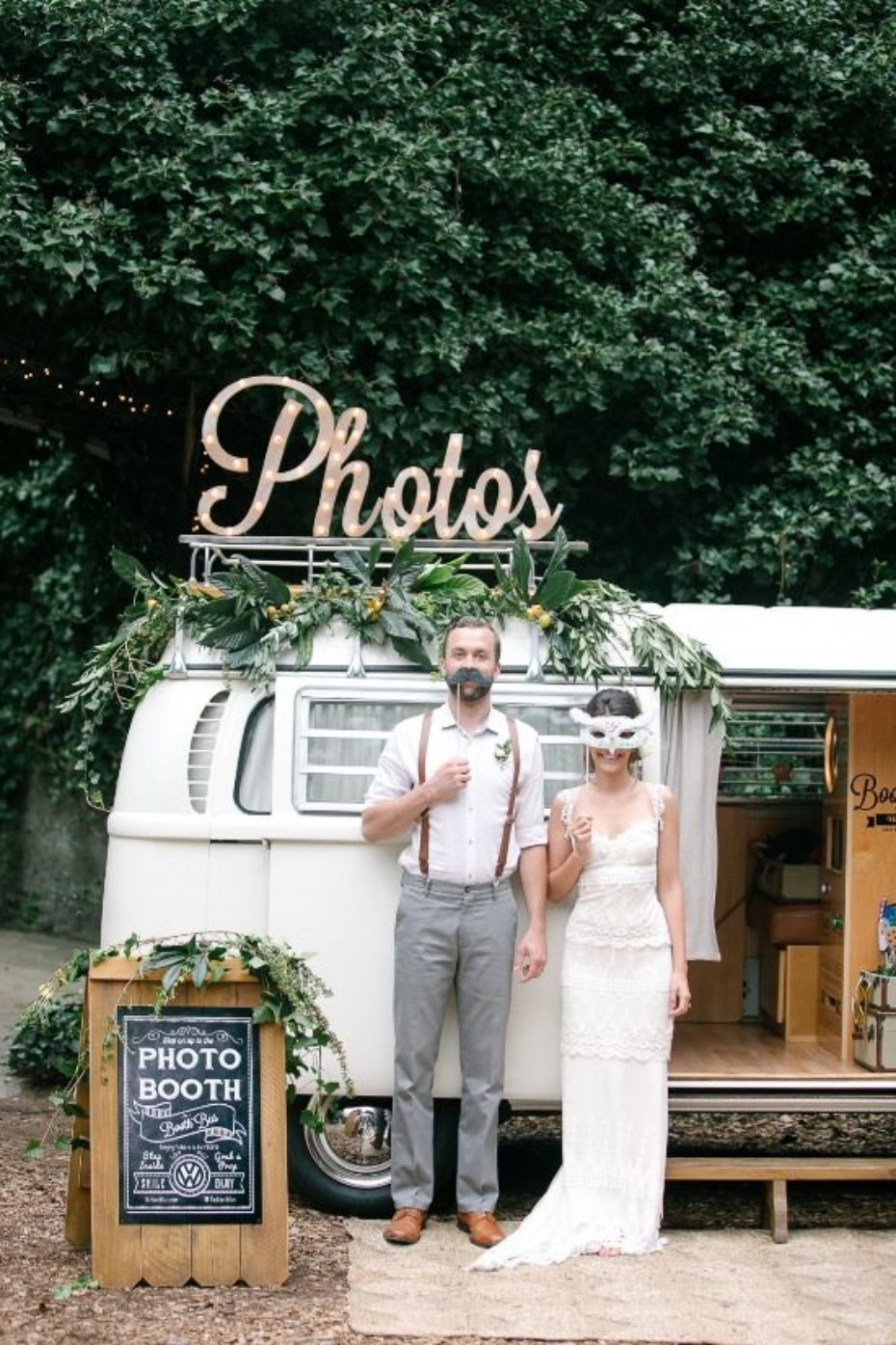 Wedding couple at a photo booth with playful mustache and mask