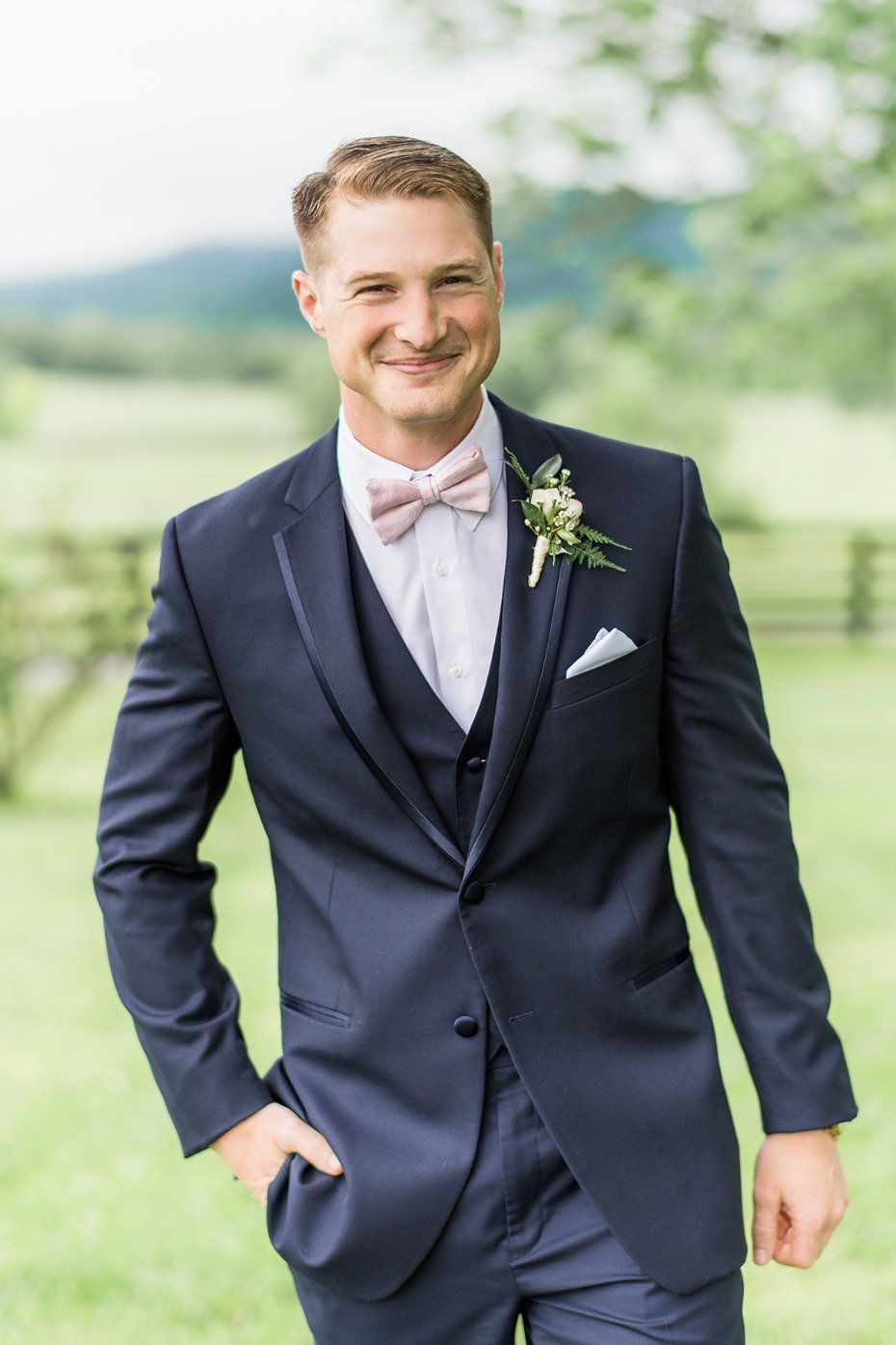 groom in soft pink bow tie and navy suit
