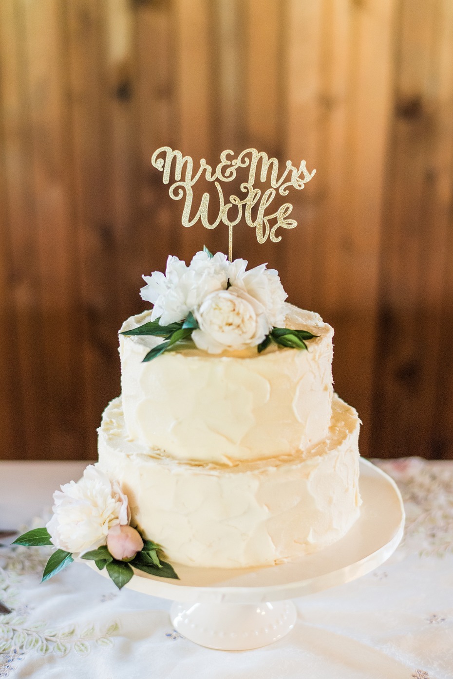 dirty frosted wedding cake with floral topper