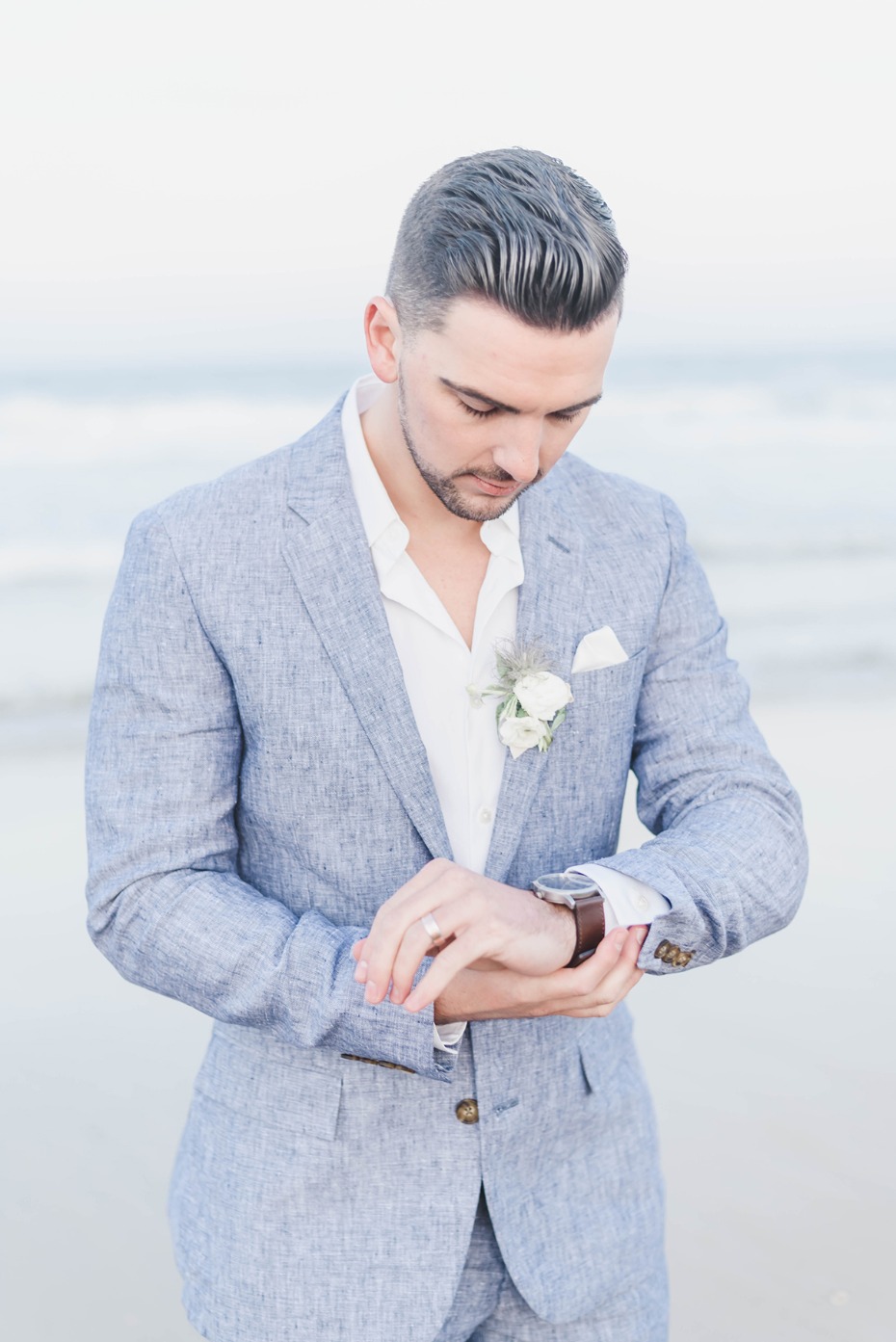 groom in heather grey suit for the beach