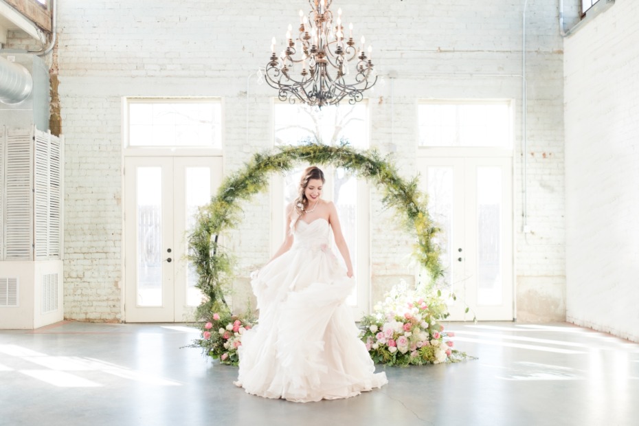 bride in front of a floral arch