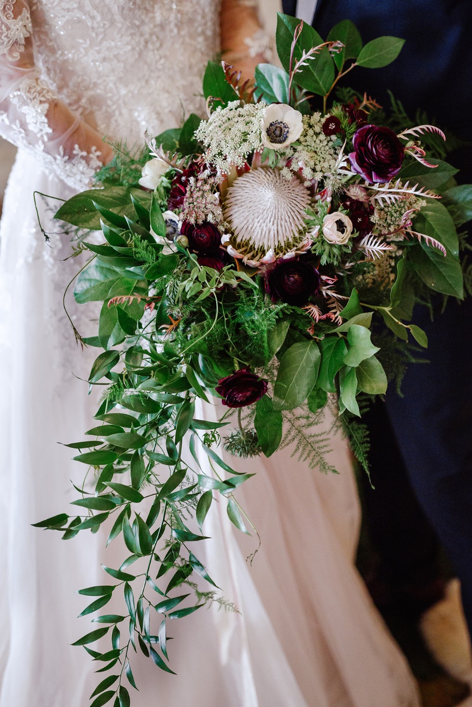 protea wedding bouquet with burgundy and white florals