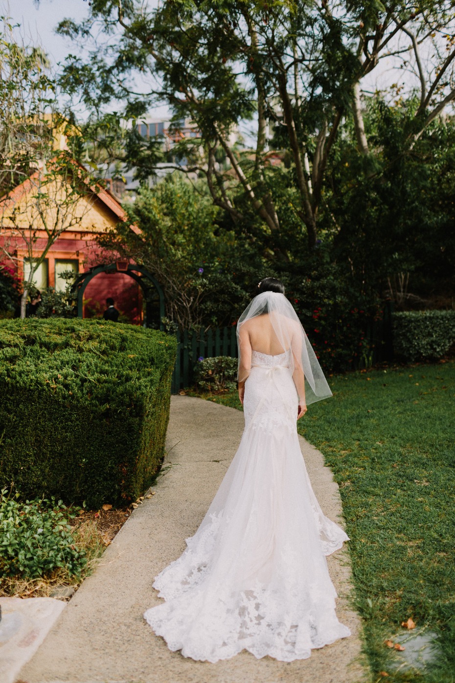 Bride walking down path in lace wedding dress outdoors