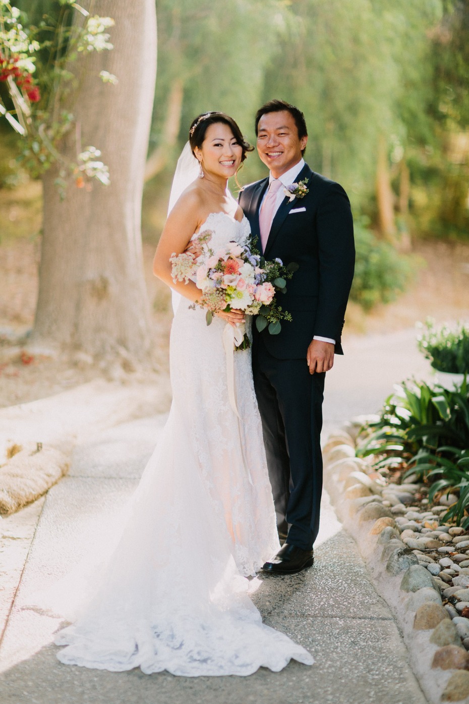 Happy Asian couple posing together on their wedding day