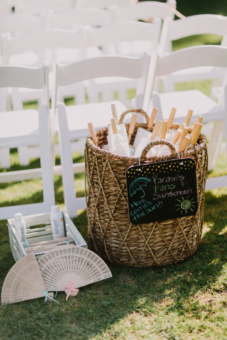 Wedding guest favors basket with fans and sunscreen, outdoors