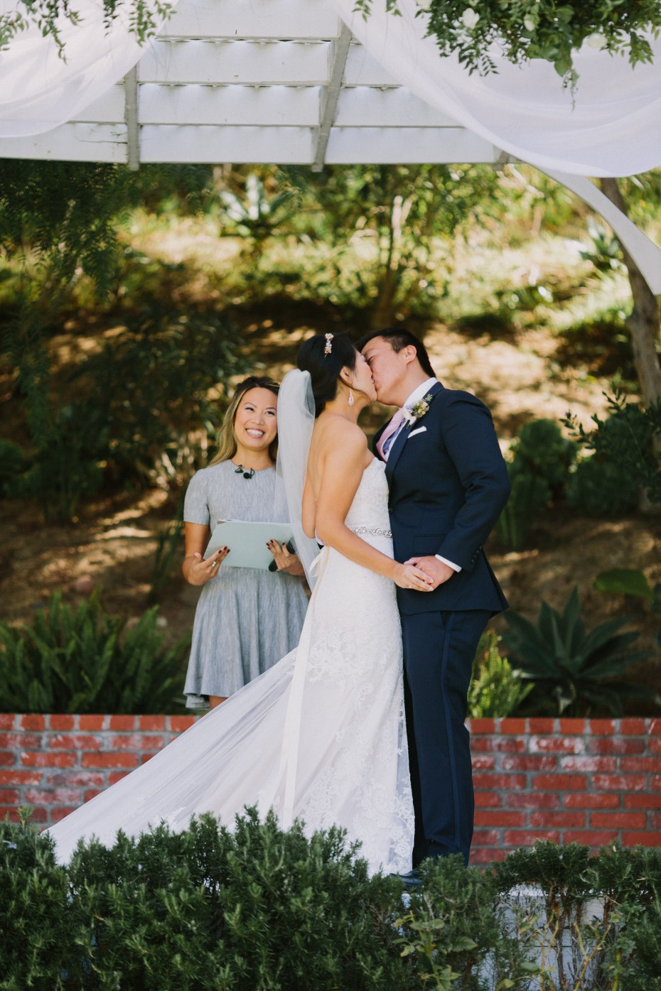 Bride and groom share a kiss at outdoor wedding ceremony