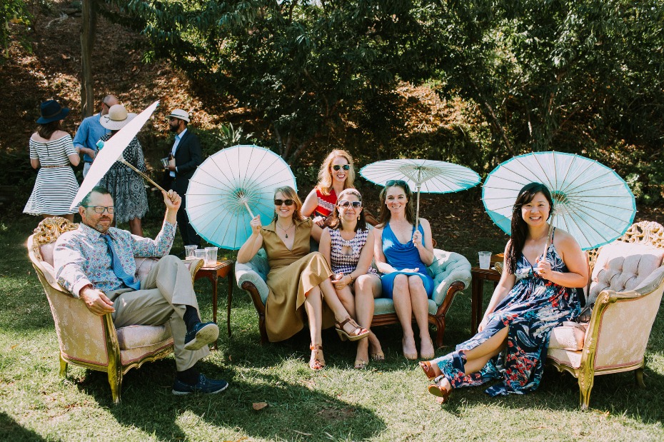 Group of people relaxing outdoors with parasols on garden chairs
