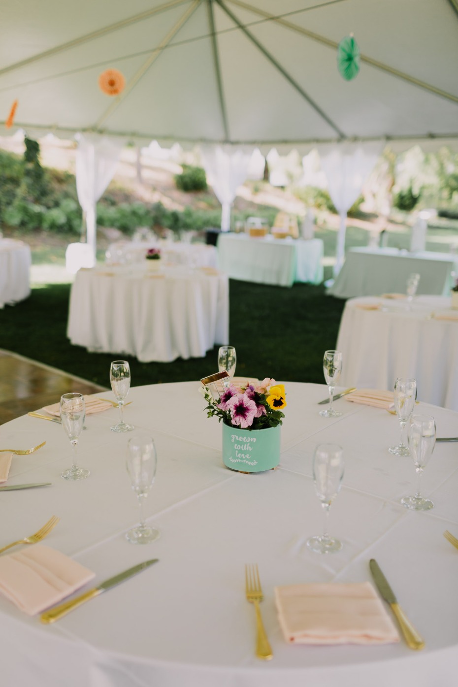 Wedding reception table with flower centerpiece under a tent