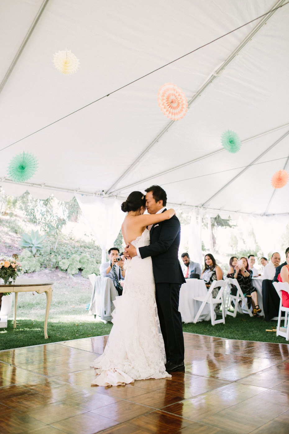 Bride and groom share their first dance under a tent at wedding