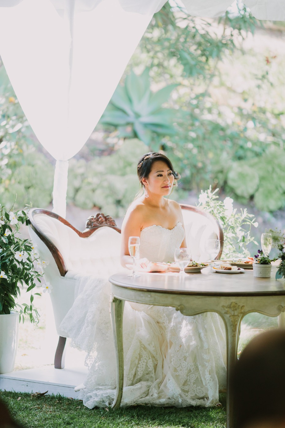 Beautiful bride in a lace wedding dress at an outdoor reception