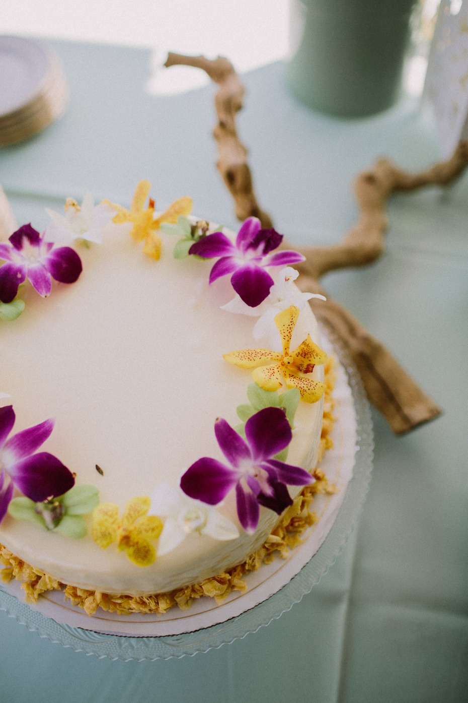 Beautiful cake decorated with vibrant purple orchids and yellow flowers