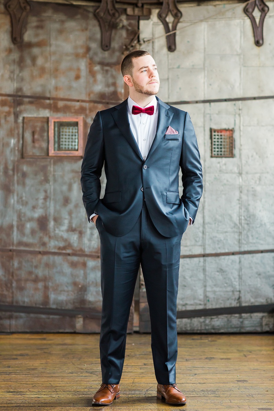 groom in navy suite and red bow tie
