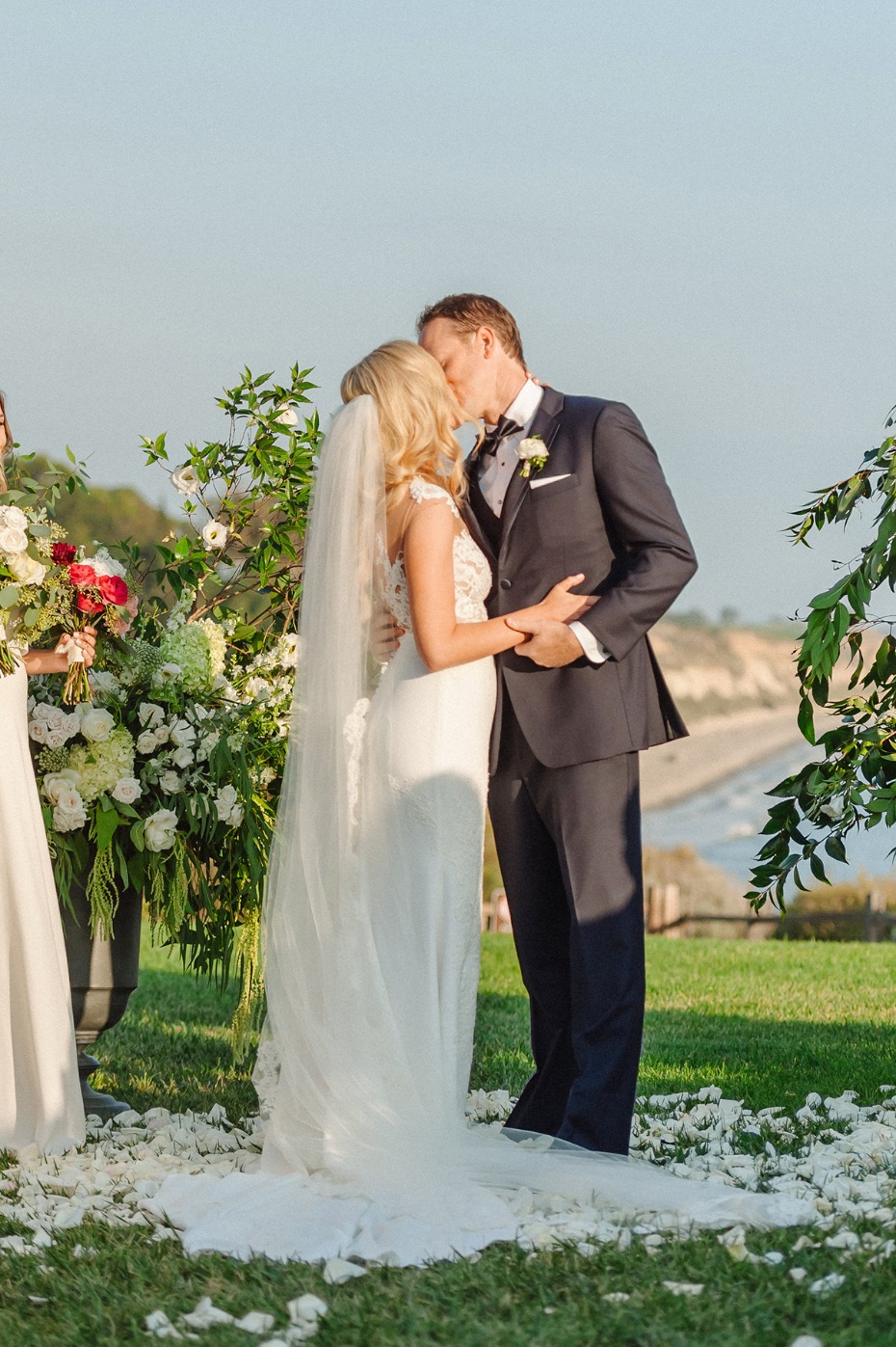 Newlyweds share a kiss during an outdoor wedding ceremony