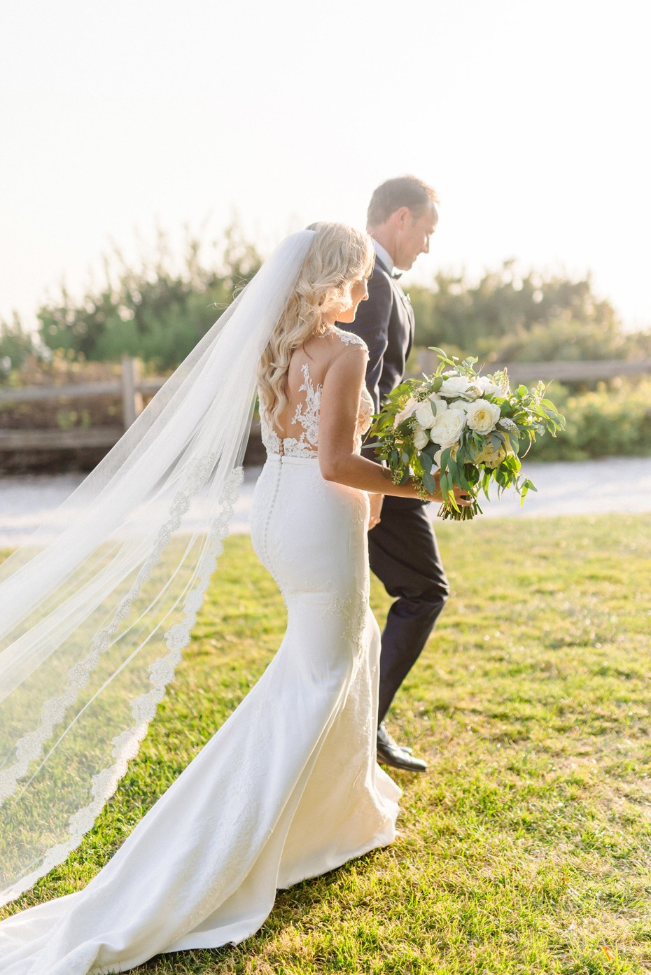 Bride walking down the aisle with her father at outdoor wedding ceremony