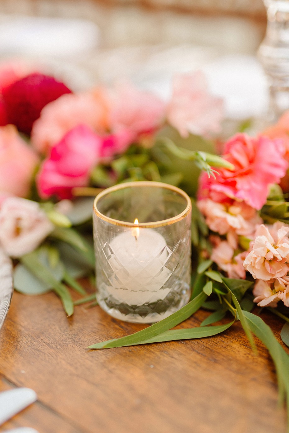 Romantic candle with flowers on a wooden table setting for a celebration