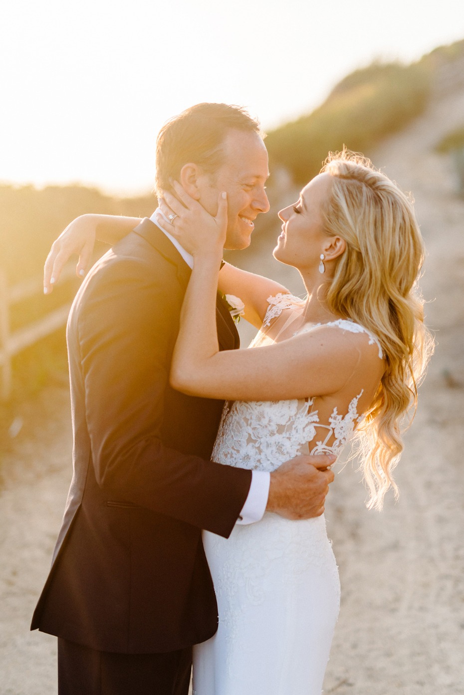 Happy couple embrace in the warm sunlight during their wedding day