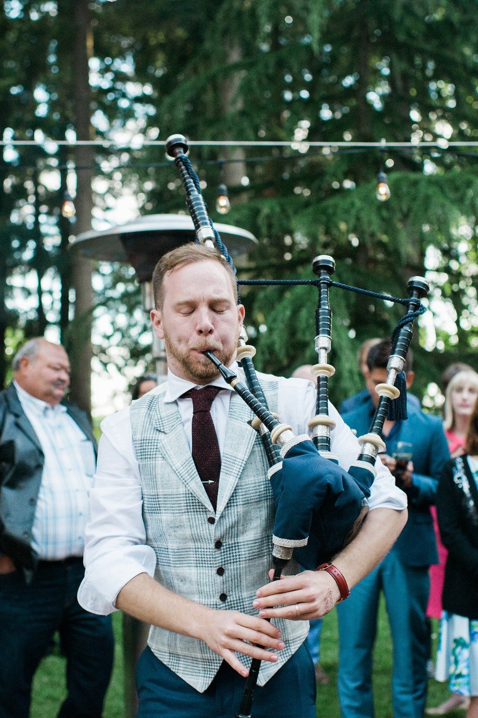 groom playing the bagpipes to his new wife